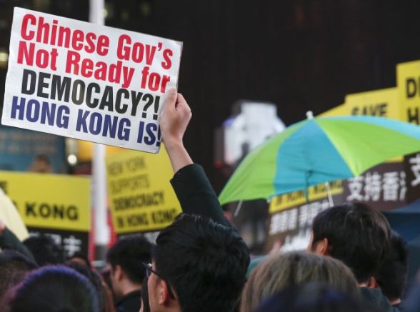 Demonstrators hold signs and umbrellas in support of Hong Kong's pro-democracy marches, at Times Square in New York